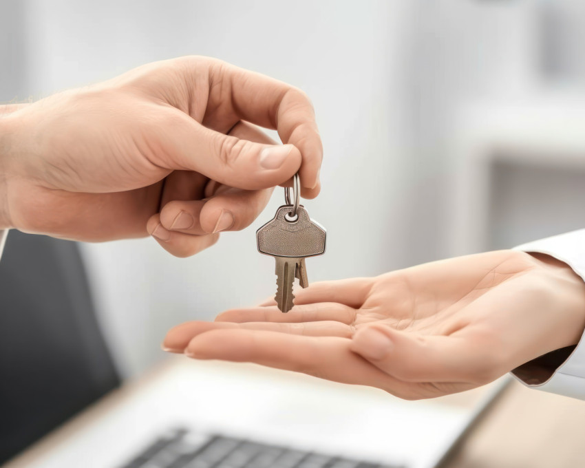 Realtor hands over keys to new apartment in mortgage purchase sealing the deal with the buyer in a real estate transaction