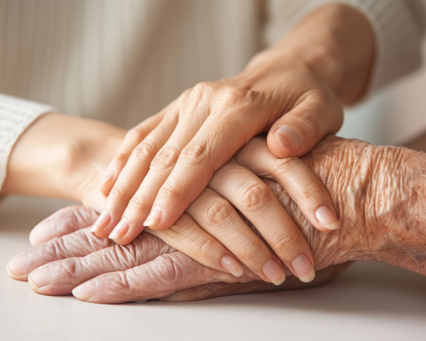 Mature wife or carer holding aged husband hands expressing care and support