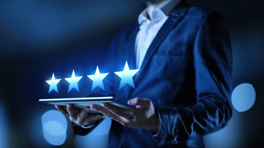 Businessman holding tablet showing virtual five stars receiving feedback