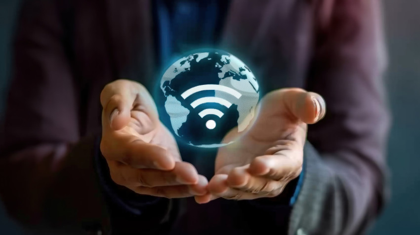 Hands holding wifi and globe icons showing global connectivity through wireless technology