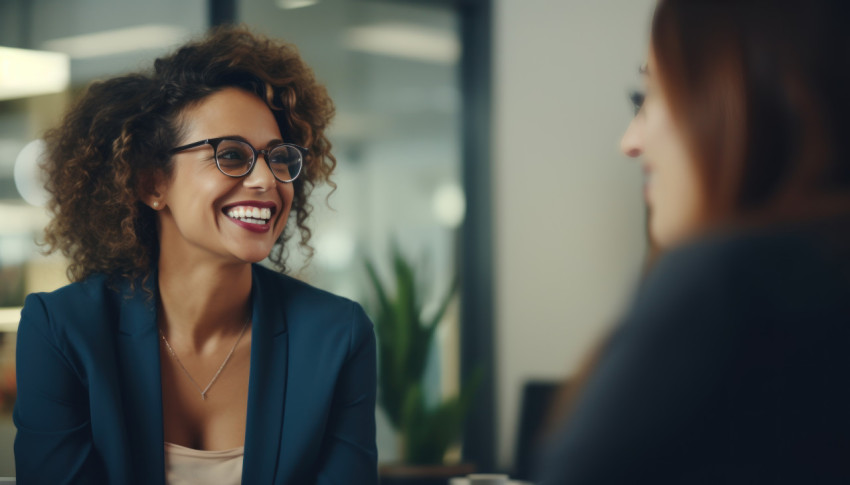 Two women wearing glasses are busy discussing work and exchanging ideas in a friendly atmosphere