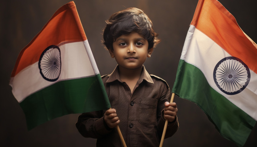 A sweet little boy holding two indian flags