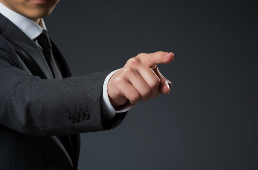 A business man in a suit pointing to something on a gray background, seo stock images for marketing campaigns