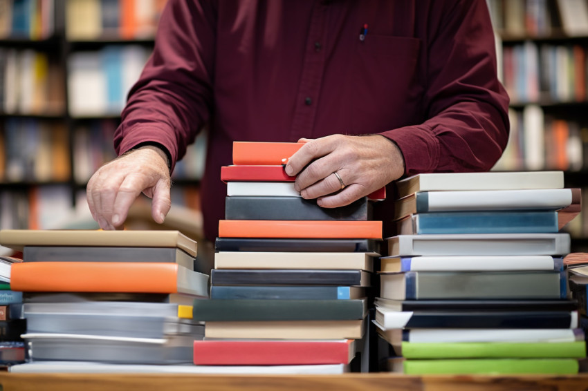 Bookstore owner with book and laptop