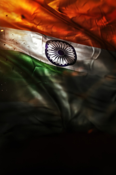 An indian flag with a focus on its tricolors set against an abstract background celebrating independence day