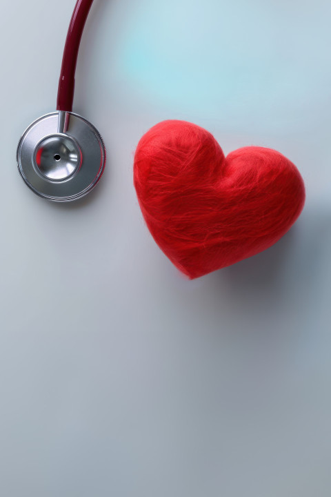 A red heart shape and stethoscope on a white background symbolize heart health and medical care