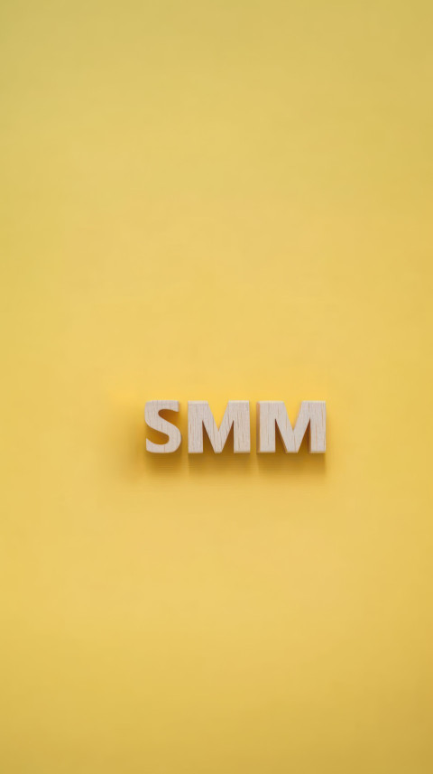 SMM letters made of wooden blocks on a light yellow background